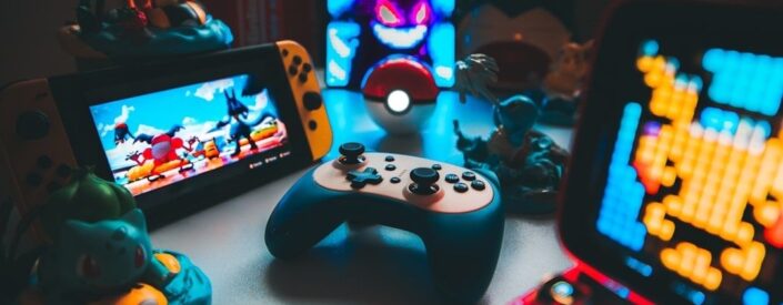 Retrospelskonsoler, handkontroll och spelprylar på ett belyst bord