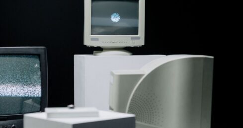 Flera äldre CRT-tv-apparater och datorskärmar mot svart bakgrund