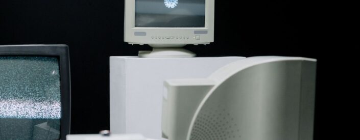 Flera äldre CRT-tv-apparater och datorskärmar mot svart bakgrund