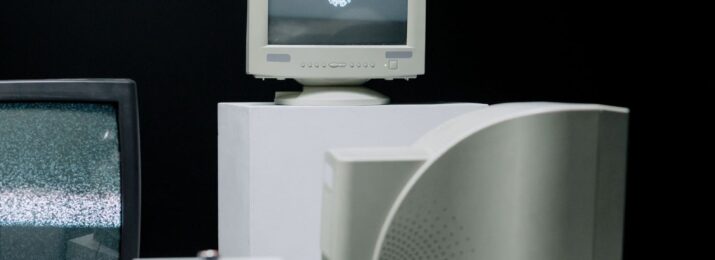 Flera äldre CRT-tv-apparater och datorskärmar mot svart bakgrund